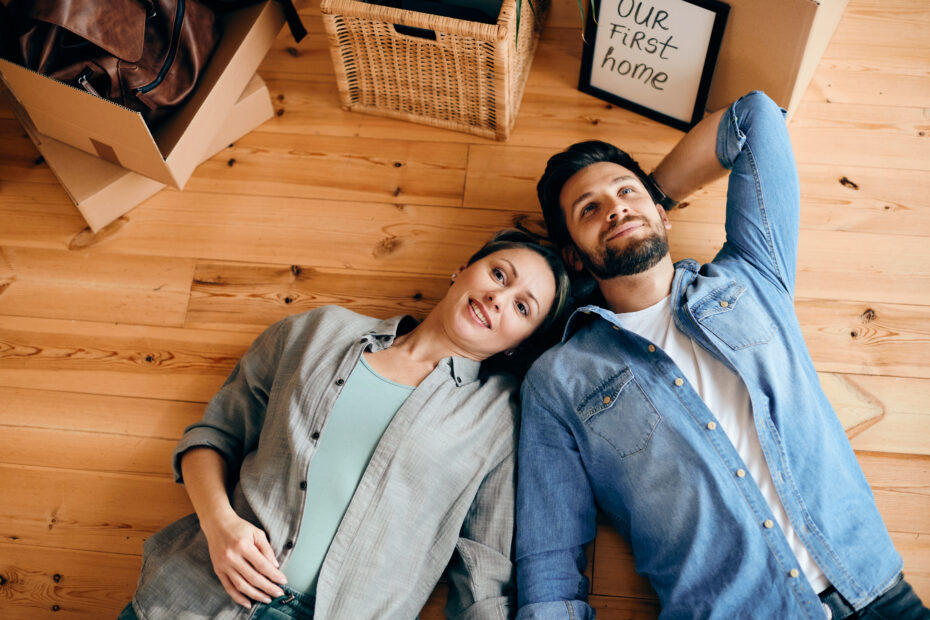 Couple lying down on floor in their new home